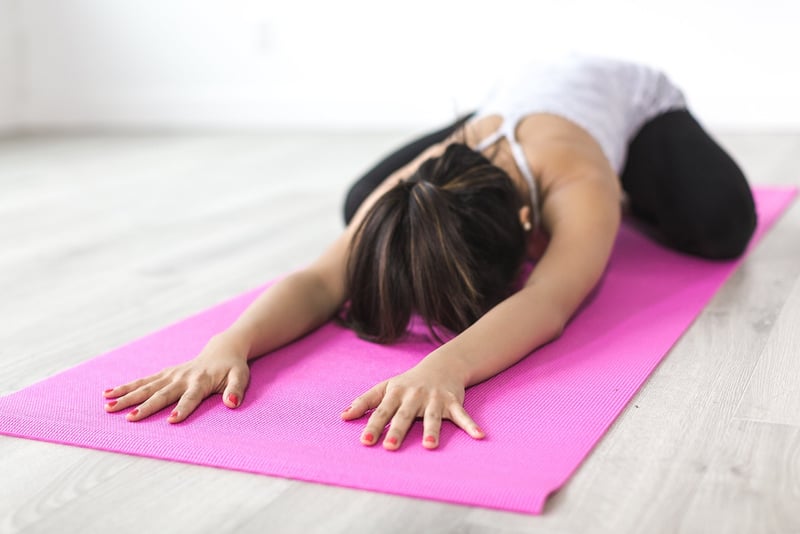Woman practicing yoga on the beach